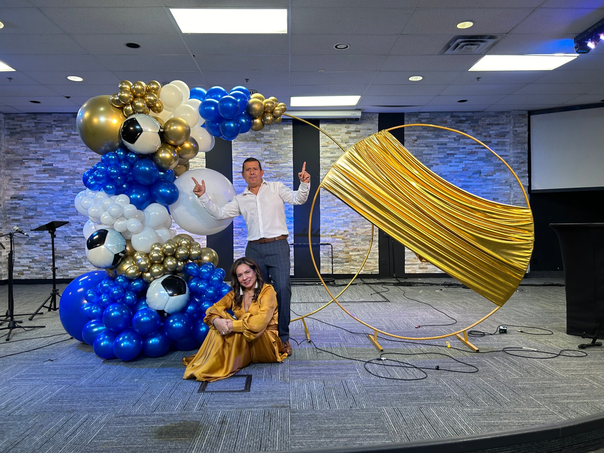 Luxury Soccer Balloon Backdrop with a gold arch, blue and white balloon arrangement, and soccer-themed decorations for a sports event.