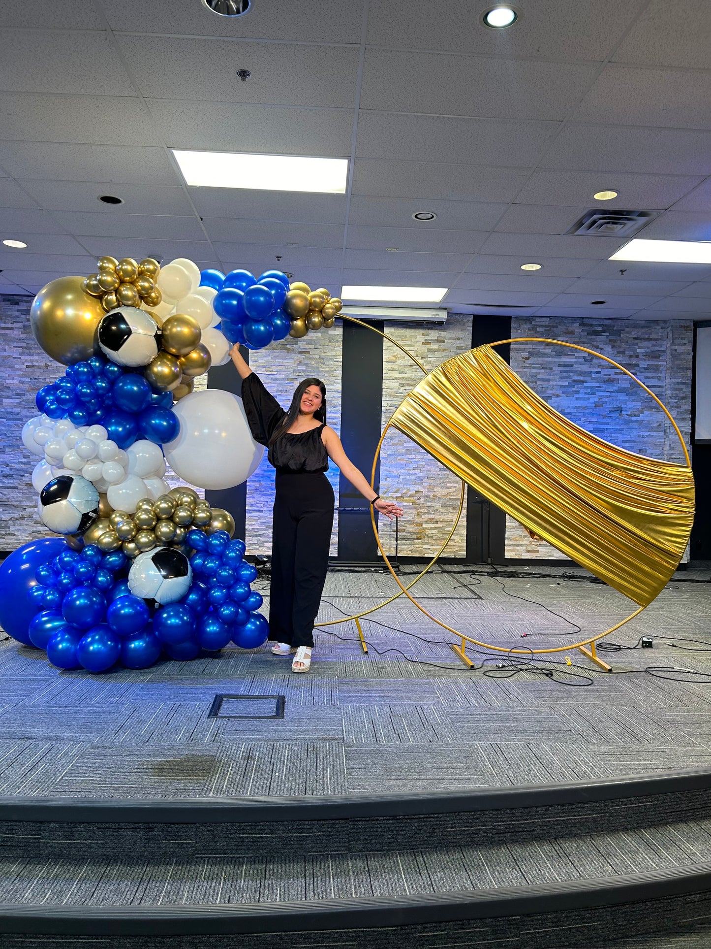 Luxury Soccer Balloon Backdrop with a gold arch, blue and white balloon arrangement, and soccer-themed decorations for a sports event.