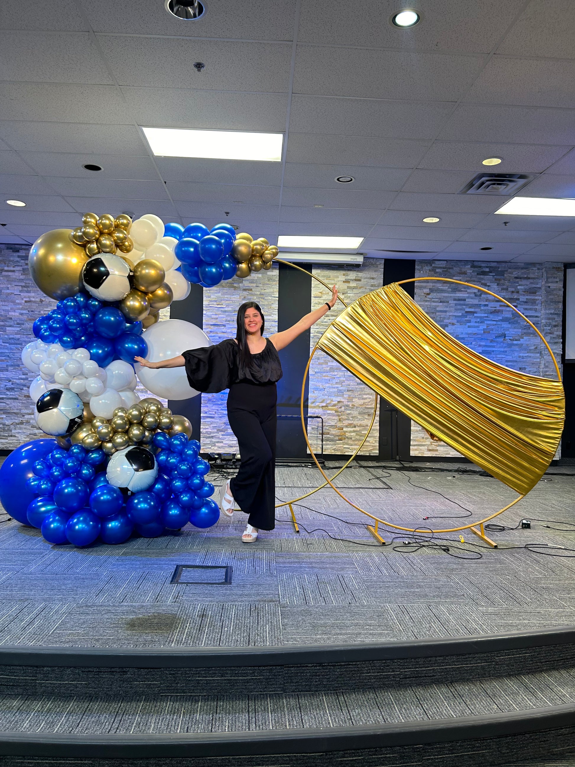 Luxury Soccer Balloon Backdrop with a gold arch, blue and white balloon arrangement, and soccer-themed decorations for a sports event.