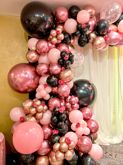 Luxury Balloon Garland featuring pink, black, and rose gold balloons with floral accents, perfect for elegant events and celebrations.
