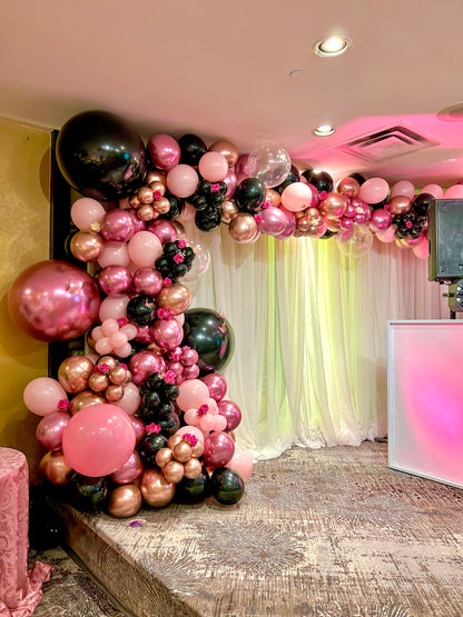 Luxury Balloon Garland featuring pink, black, and rose gold balloons with floral accents, perfect for elegant events and celebrations.