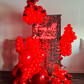 Luxury Red Shimmery Wall Balloon Installation with a red sequin wall, premium balloon garland, LED neon sign, florals, and mirror balls for an elegant event setup.