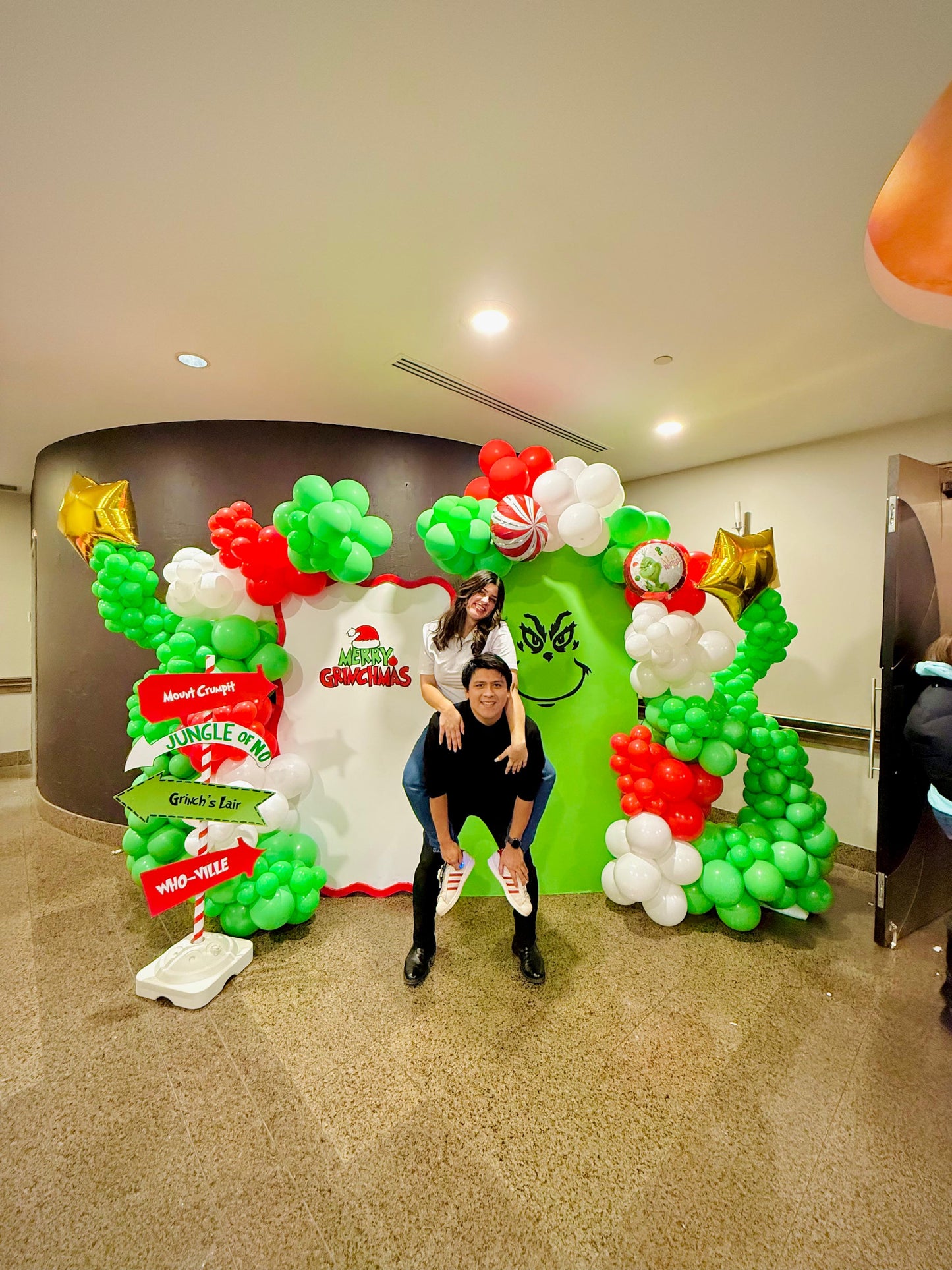 Grinch balloon decor setup with festive balloon garlands and backdrops.

