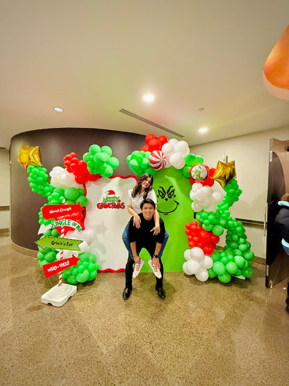 Grinch balloon decor setup with festive balloon garlands and backdrops.

