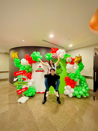 Grinch balloon decor setup with festive balloon garlands and backdrops.

