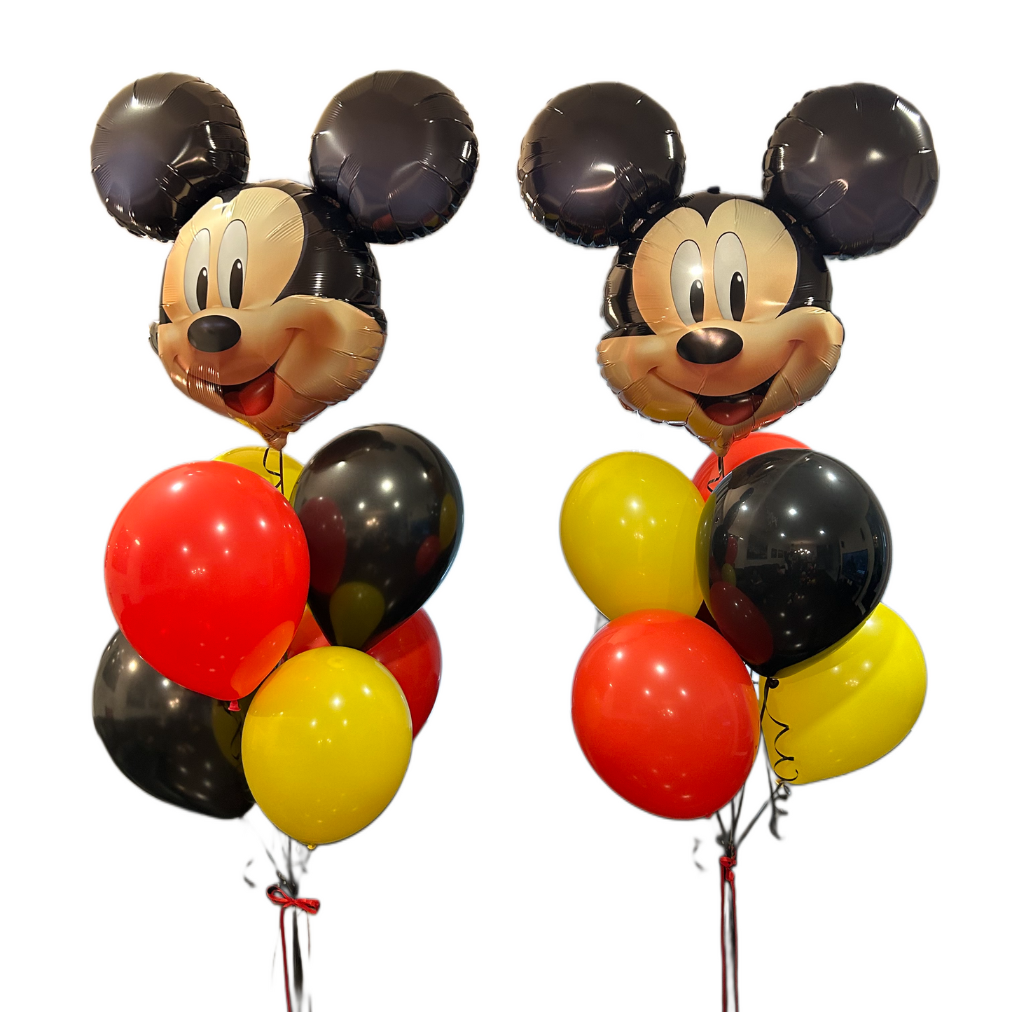 Two Mickey Mouse balloon bouquet arrangements on a plain white background, each featuring a Mickey-shaped foil balloon with black and beige ears and face, surrounded by black, red, and yellow balloons.