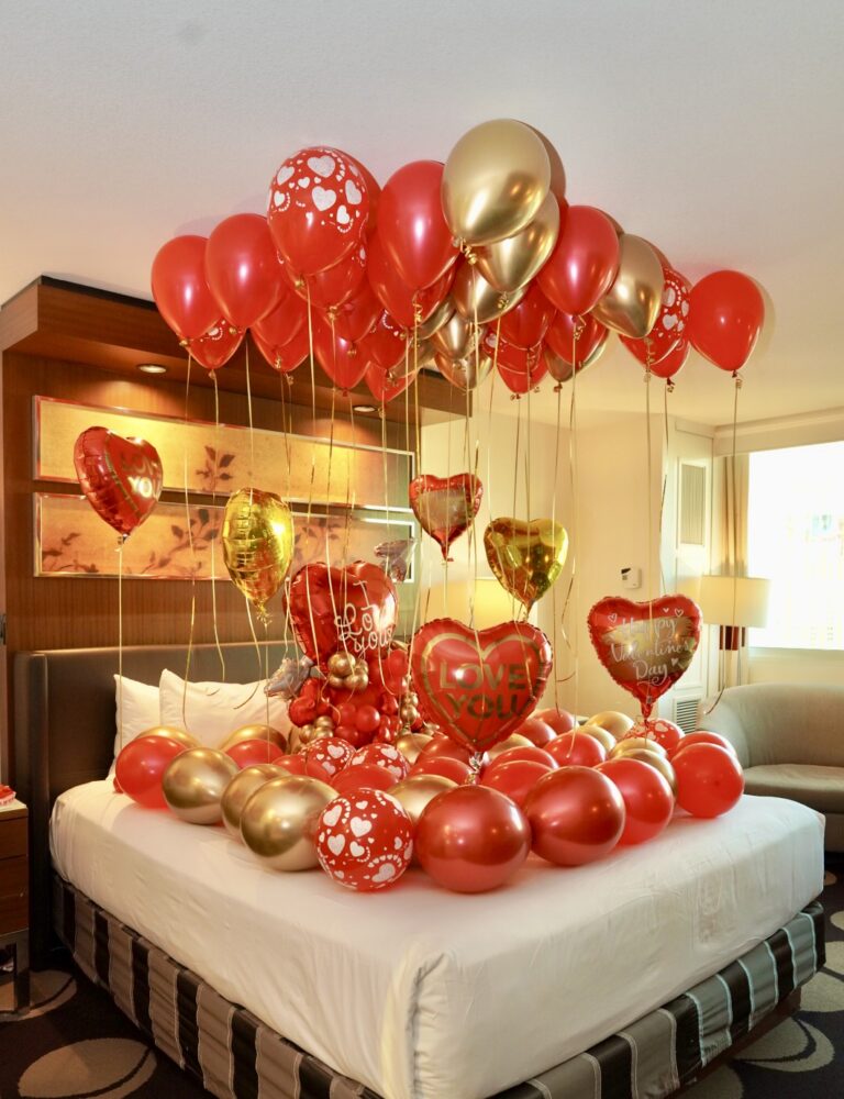Romantic Decor – Elegant room setup with ceiling balloons, bed balloons, and heart-shaped helium balloons