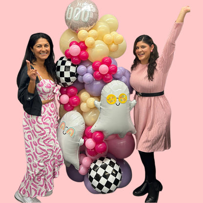 Spooky Chic Balloon Tower with ghost balloons, pastel colors, checkered accents, and a "Hey Boo" topper for Halloween celebrations.
