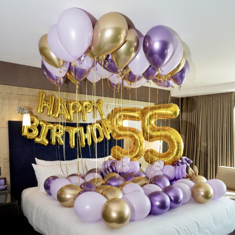 Surprise Birthday Hotel Decor with colorful balloons, "Happy Birthday" banner, and balloon number stands