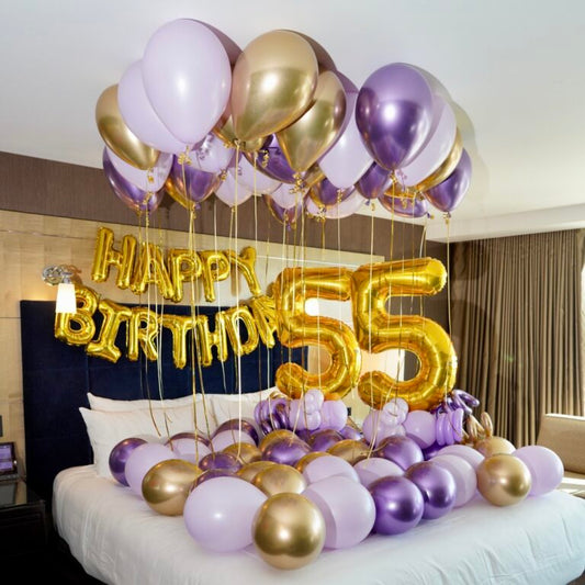 Surprise Birthday Hotel Decor with colorful balloons, "Happy Birthday" banner, and balloon number stands