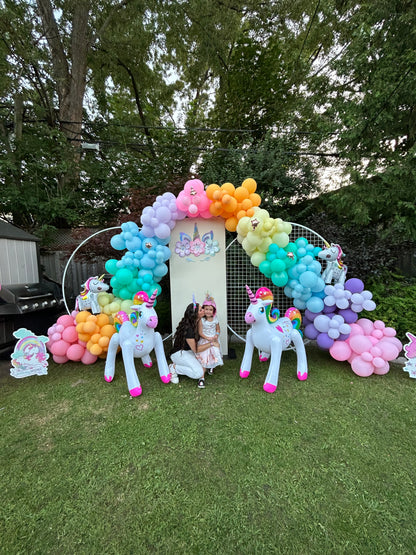 Magical Unicorn Balloon Backdrop with a pastel rainbow balloon arch and inflatable unicorn decorations for a kids’ party in Toronto.