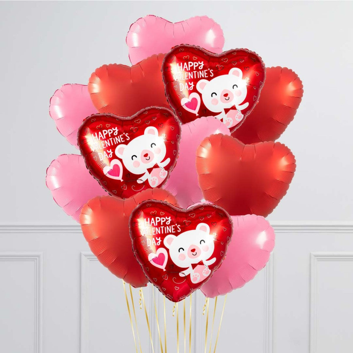 A dozen 17-inch heart-shaped foil balloons, helium-filled with a balloon weight.
