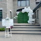 Wedding Balloon Decor featuring a greenery backdrop, organic balloon garland, and floral pedestals with dessert cart.