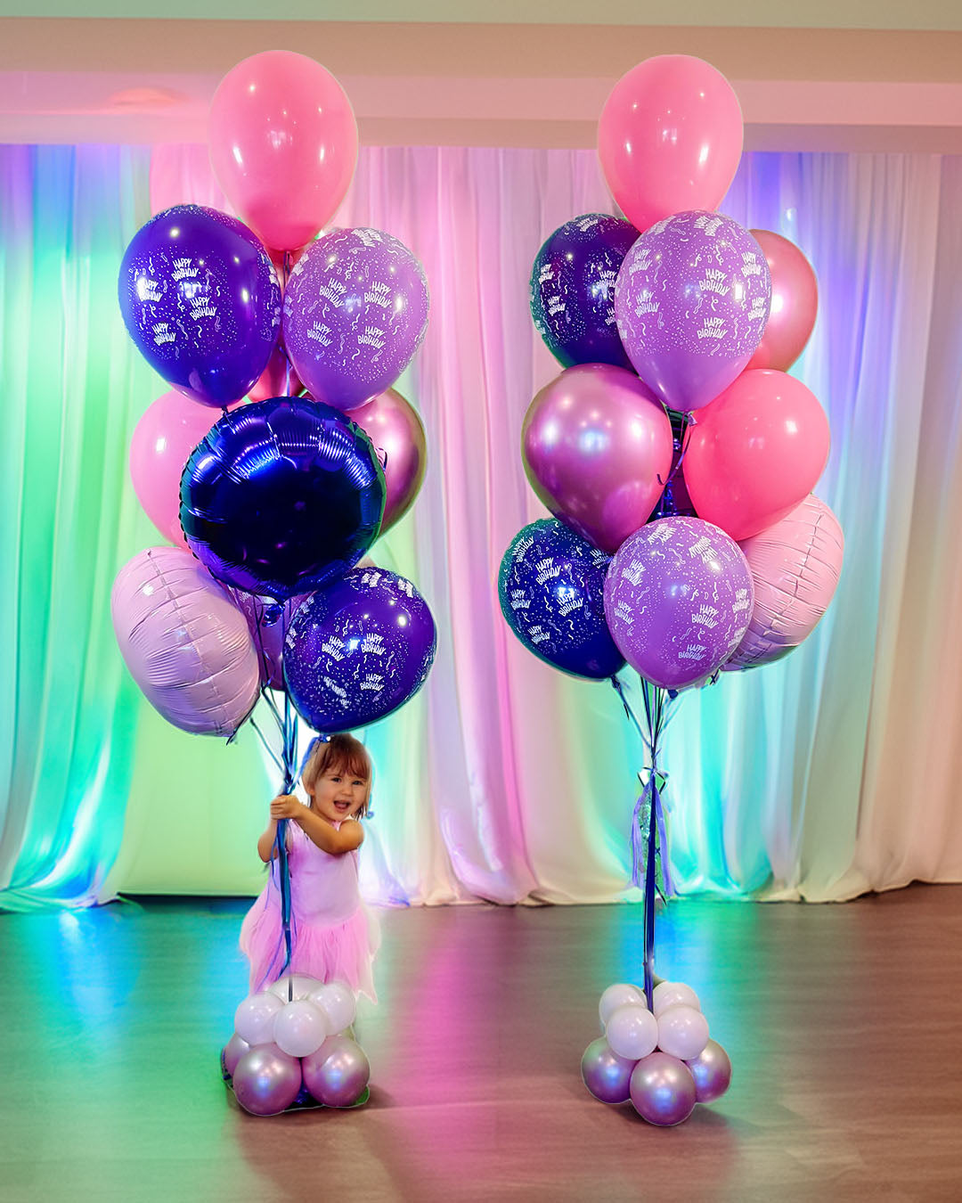 Wooow Jumbo Birthday Bouquets Toronto – large pink and purple birthday balloon bouquets with a child holding balloons, by Wooow Balloons