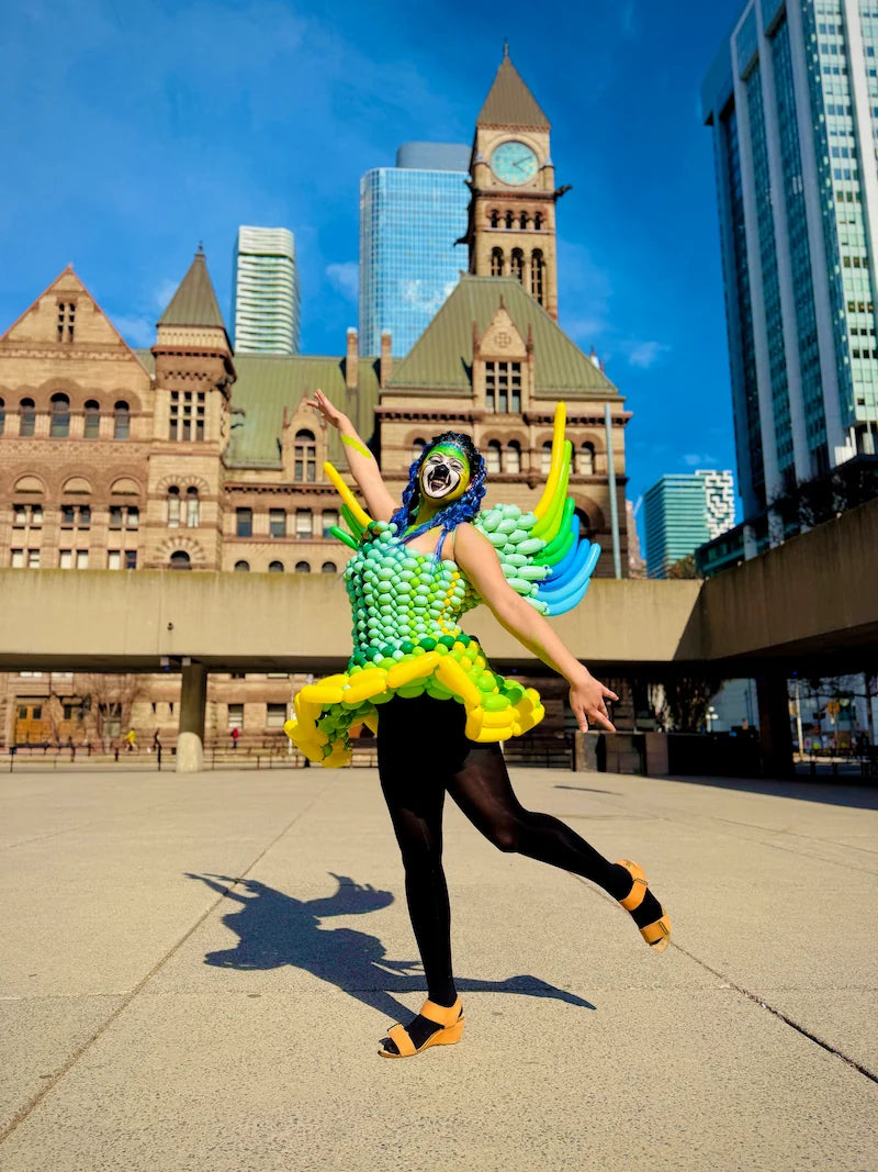 Balloon artist modeling a custom winged balloon dress at Nathan Phillips Square in downtown Toronto