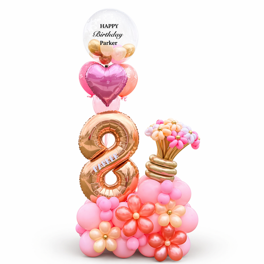 Pink and rose gold birthday balloon arrangement with number 8, bubble balloon and floral base in Toronto