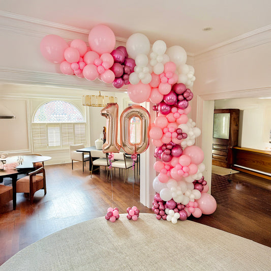 Luxury birthday balloon garland setup in a Toronto home with organic balloons and milestone number balloons