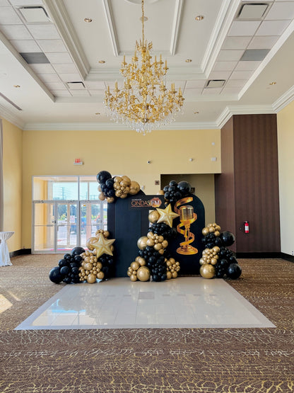 Glamorous black and gold balloon decor with chandelier and custom backdrop for Toronto gala event.