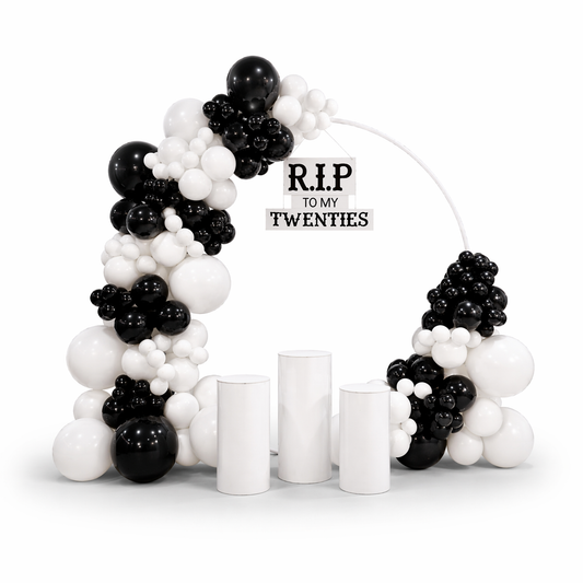 Black and white balloon garland arch with backdrop stand and pedestals, modern event decor setup for birthdays and celebrations in Toronto