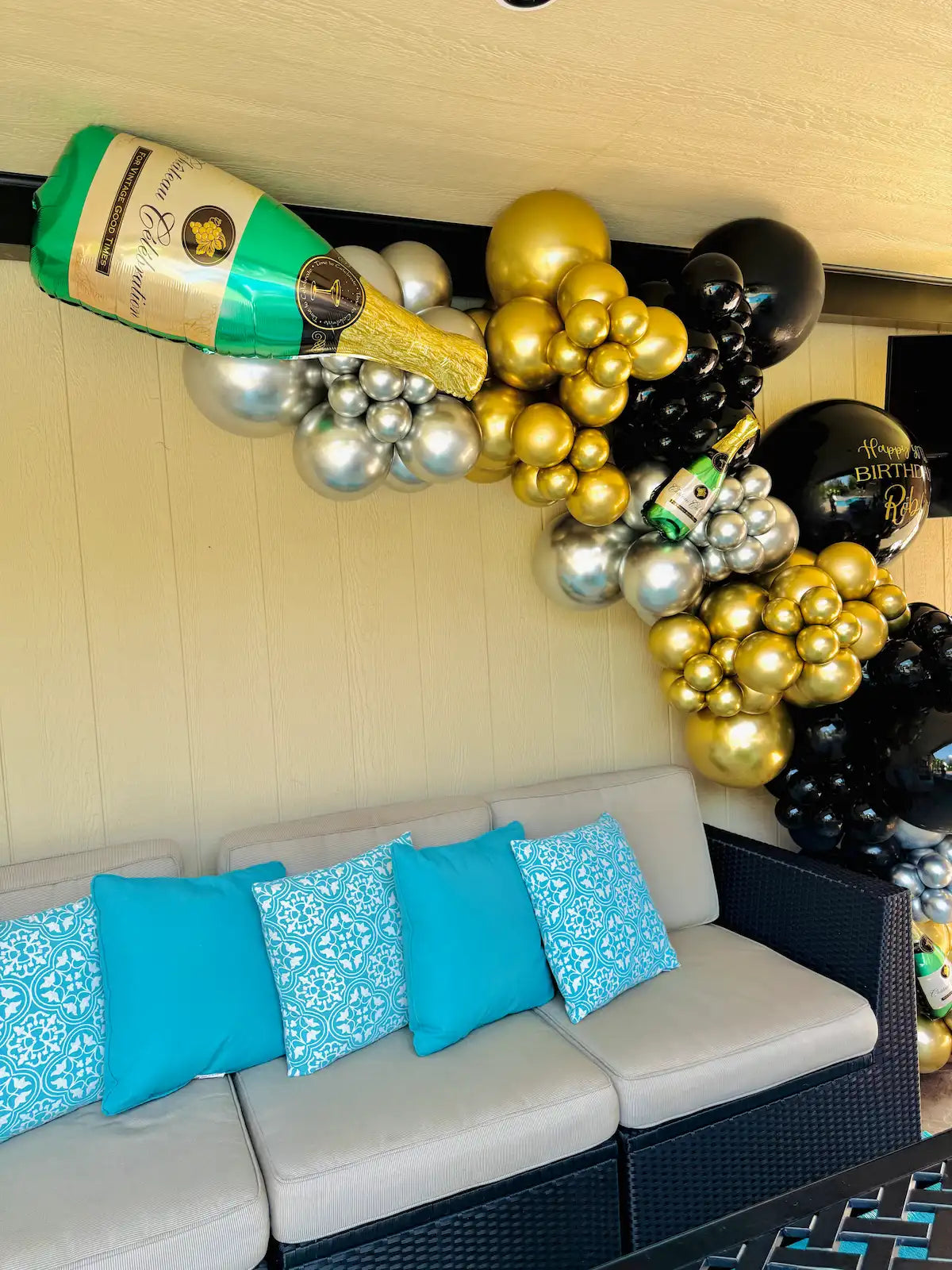 Black, gold and silver balloon garland with champagne bottle balloons for a luxury birthday party in Toronto.