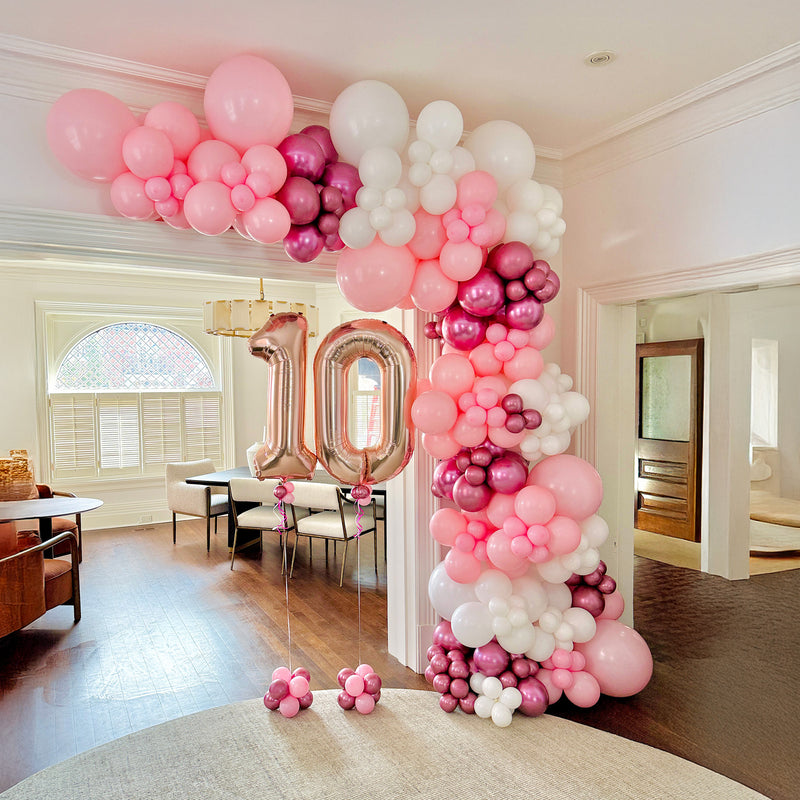 Custom pink balloon installation with milestone number balloons for a birthday party