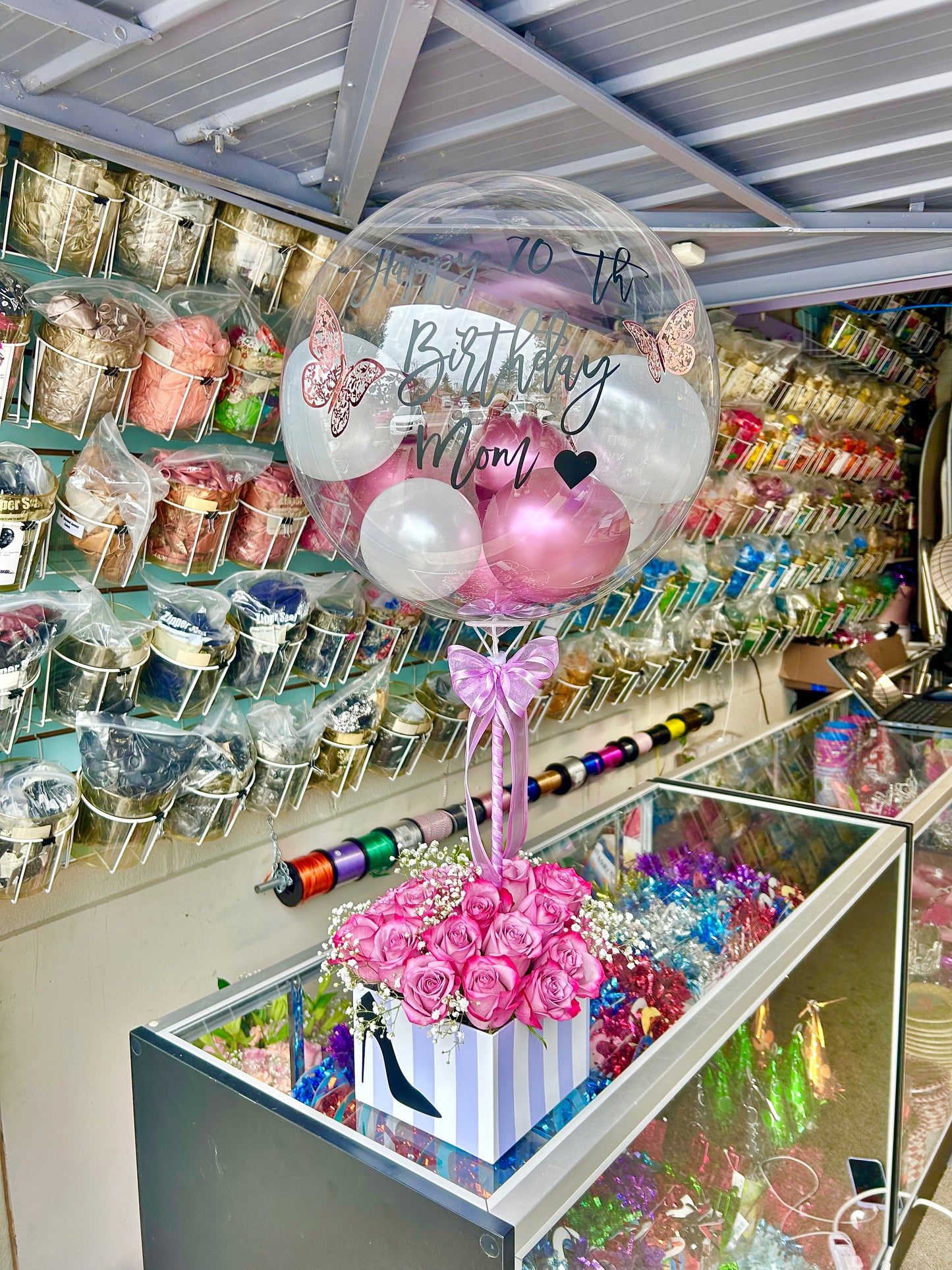 Bloom Box featuring roses, baby’s breath, and a clear customizable bobo balloon