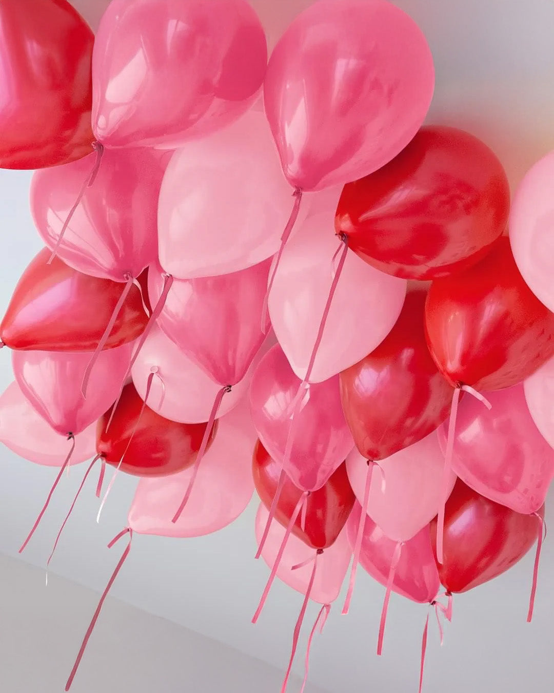 Loose helium balloons floating on ceiling for birthday celebration