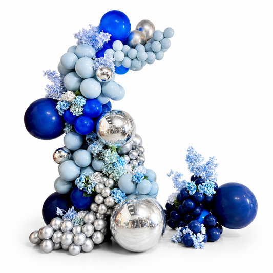 Luxury blue and silver freestanding balloon garland with chrome balloons, floral accents, and organic balloon styling for birthdays, graduations, and events in Toronto