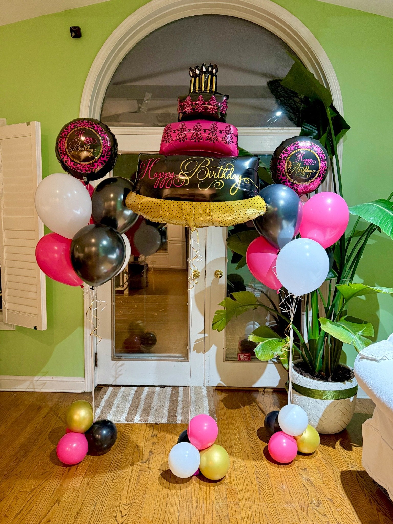 Modern black, white, and pink birthday balloon setup Toronto – Elegant helium balloon columns and cake balloon