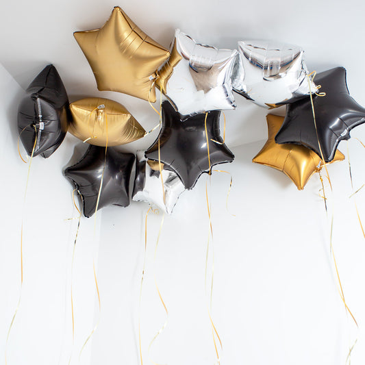 New Year’s balloon stars in black gold and silver floating on ceiling in Toronto
