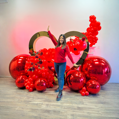 Full luxury proposal balloon decoration in Toronto with gold heart backdrop, red balloons, florals, and mirror ball accents