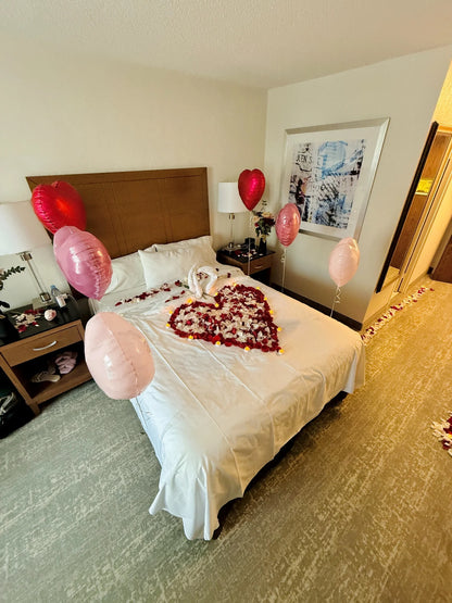 Valentine’s hotel room decor with fresh petals and heart-shaped balloons – Wooow Balloons Toronto.