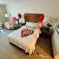 Romantic surprise setup with pink and red balloons, rose petals, and candles in Toronto