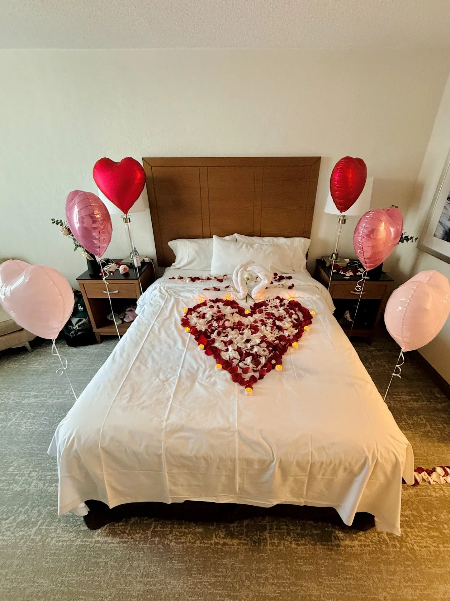 Elegant romantic bed decoration with red and pink heart balloons for couples in Toronto