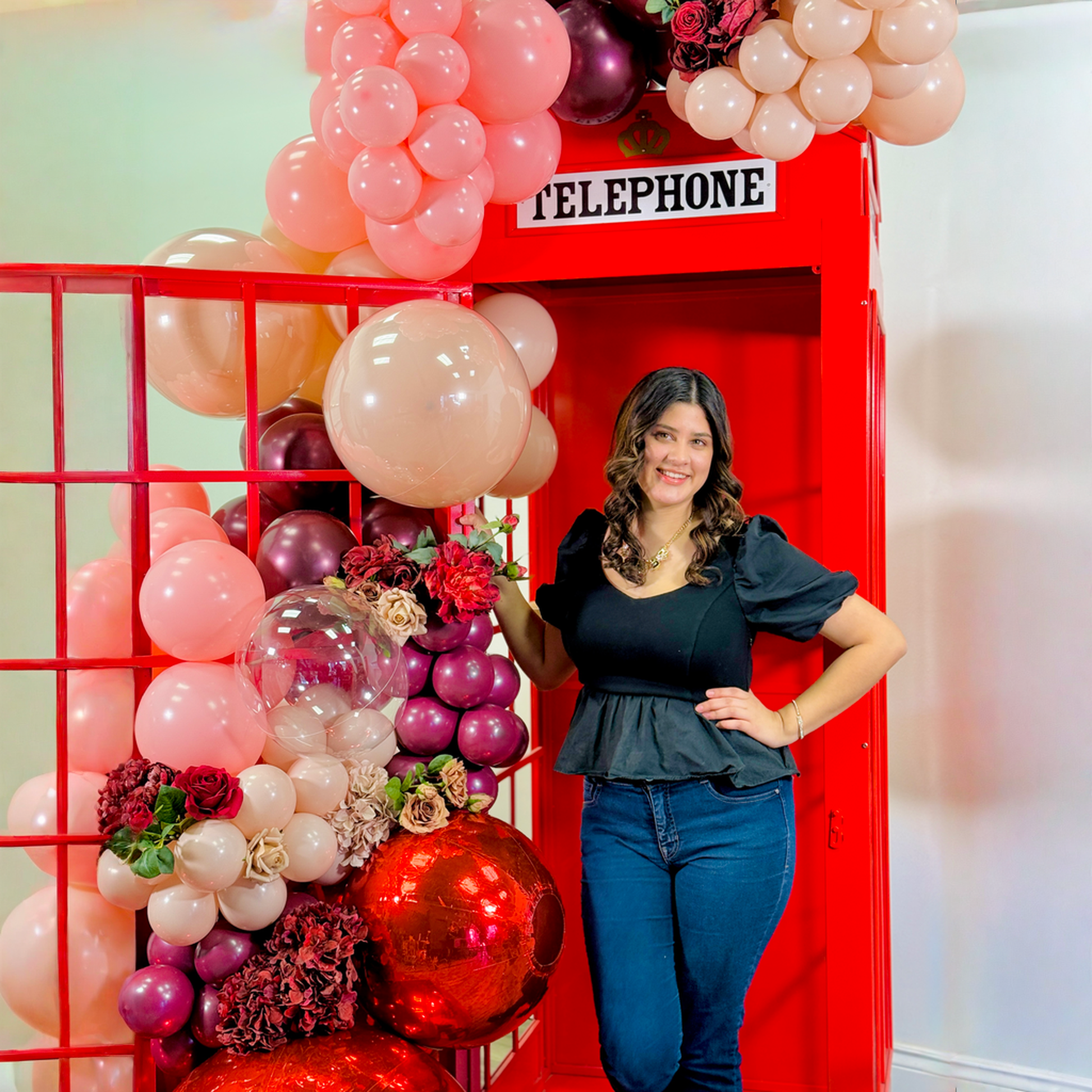 Telephone booth backdrop Toronto with premium florals and romantic balloon decor for Valentine’s Day and proposals