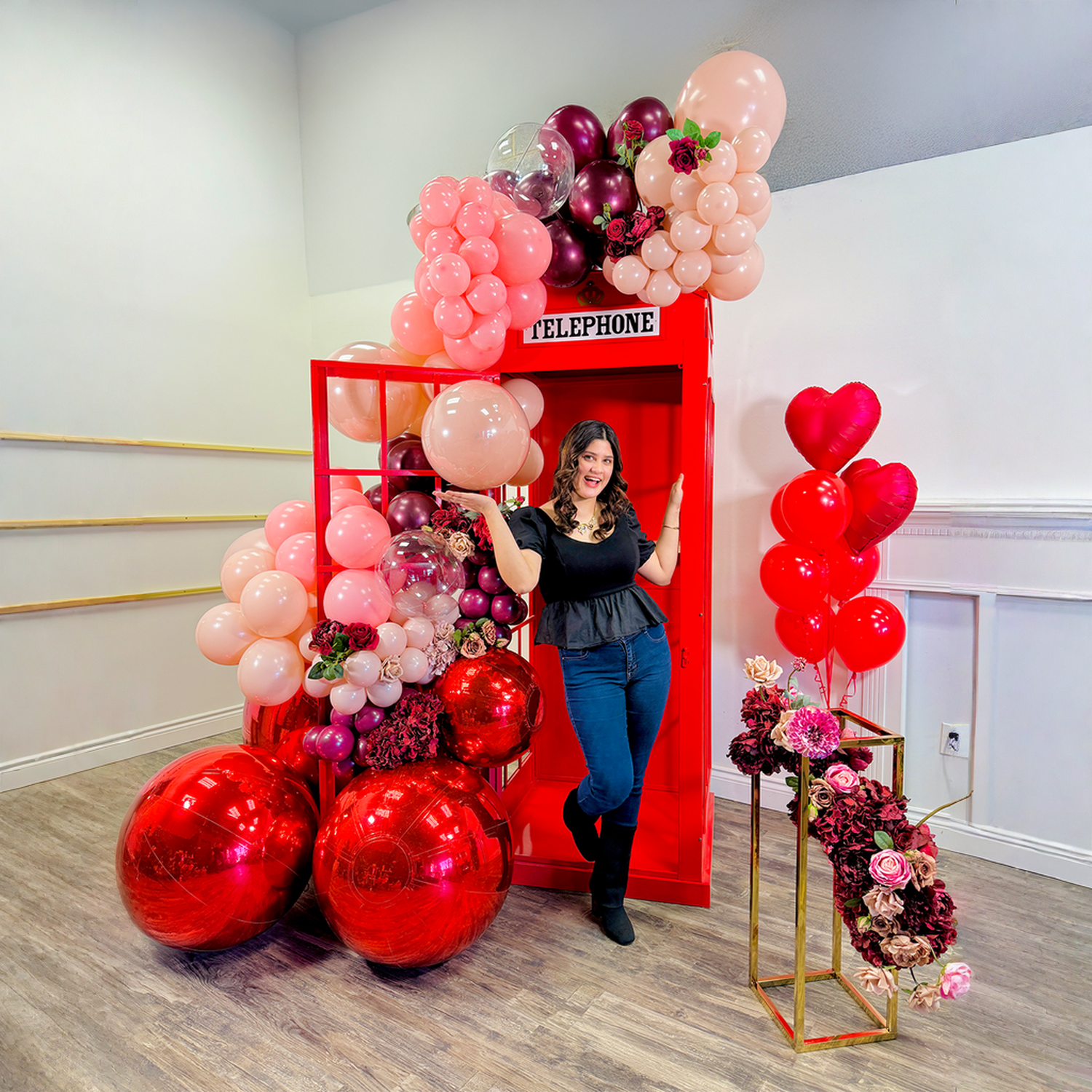 Telephone Photo Booth Backdrop Toronto with luxury red balloon garland and oversized metallic balloons for Valentine’s Day photos